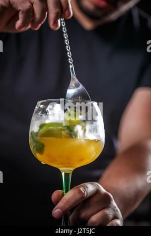 Barman est en remuant des cocktails sur comptoir bar Banque D'Images