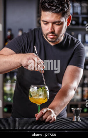 Barman est en remuant des cocktails sur comptoir bar Banque D'Images