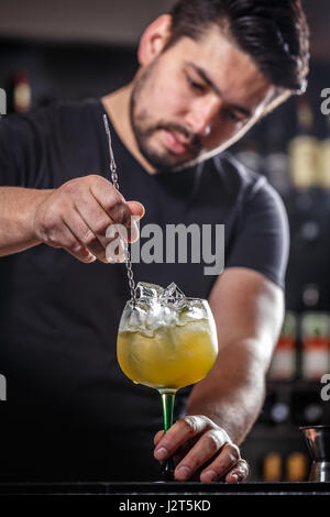 Barman est en remuant des cocktails sur comptoir bar Banque D'Images