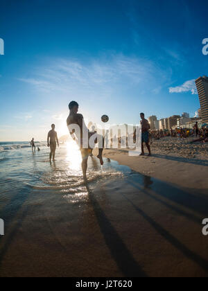 RIO DE JANEIRO - le 2 février 2013 : les jeunes Brésiliens jouent altinho beach football dans un cercle keepy uppy au coucher du soleil sur la rive de la plage d'Ipanema. Banque D'Images