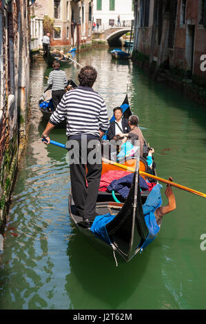 Venise - 21 avril 2013 : Gondola transporte les touristes vers le bas d'un canal pittoresque typique. Banque D'Images
