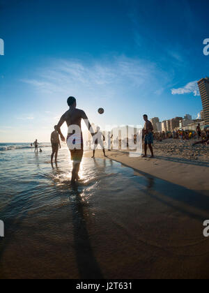 RIO DE JANEIRO - le 2 février 2013 : les jeunes Brésiliens jouent altinho beach football dans un cercle keepy uppy au coucher du soleil sur la rive de la plage d'Ipanema. Banque D'Images