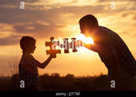 Père et fils à jouer au parc au coucher du soleil. Les gens s'amusant sur le terrain. Concept de l'enfant est prêt à aller à l'école. Banque D'Images