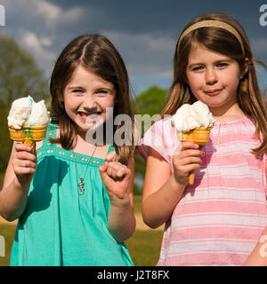 Vue sur place de deux enfants la consommation de crème glacée au soleil. Banque D'Images