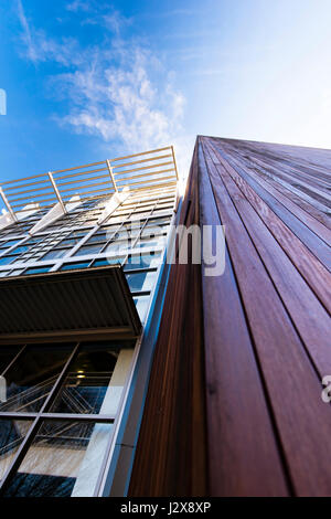 Fragments architecturaux de deux bâtiments, l'un est fait de planches en bois d'acajou, et l'autre des structures en métal et verre. Banque D'Images