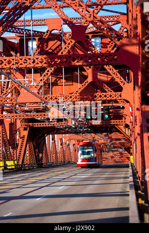 Le tramway de la ville sur une voiture rouge et un pont-levis piétonne métal a fait ​​Of structures rivetées constituant la masse de triangles de force. Le tram passe rouge Banque D'Images