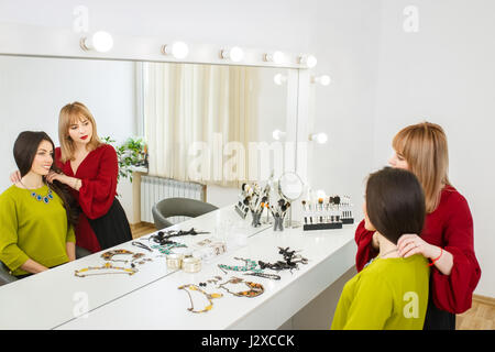 Portrait of beautiful happy young woman choosing bijoux de mode. Choix d'accessoires avec styliste Banque D'Images