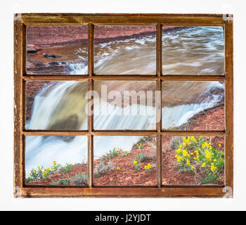 Cascade du ruisseau de fleurs sauvages comme vu par vintage, grunge, fenêtre à guillotine avec vitre sale Banque D'Images