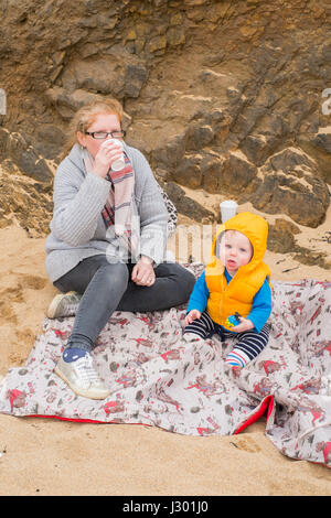 Huit mois du garçon et de sa mère à Hope Cove beach, Kingsbridge, Devon, Angleterre, Royaume-Uni Banque D'Images