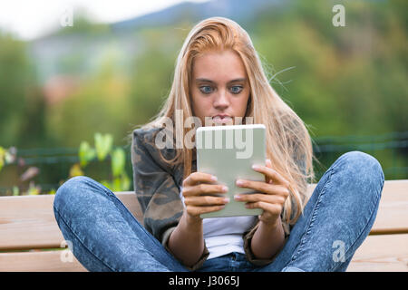 Jeune femme voir choquant ou gênant de choses sur l'internet montrant un visage très drôle Banque D'Images