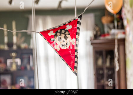 Les garçons à l'intérieur de la bannière de fête d'anniversaire pirate décoration. Banque D'Images