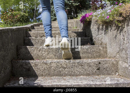 Jeune femme monte sur un escalier en béton Banque D'Images