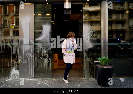 Barcelone, Espagne. 01 mai, 2017. Le 1 mai, 2017 - Barcelone, Catalogne, Espagne - une femme laisse une porte d'entrée de l'hôtel vandalisés pendant un jour peut-être anti-capitalistes manifestation à Barcelone. Crédit : Jordi Boixareu/Alamy Live News Banque D'Images