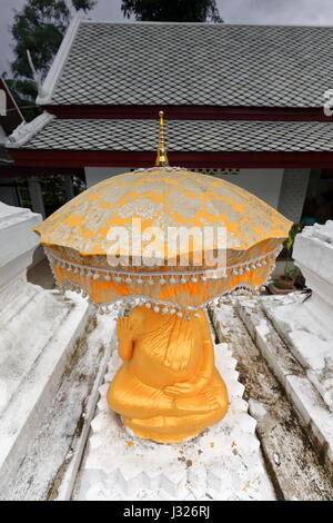 Statue dorée de Boudha assis sous parapluie d'or de Wat Pa en Phai-Bamboo monastère forestier avec peintures murales richement décoré en style Thai-Lao représentant Banque D'Images