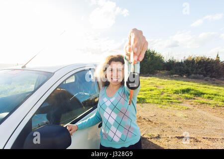 Vente, location d'auto, le consumérisme et le peuple concept - happy woman holding nouvelle clé de voiture piscine Banque D'Images