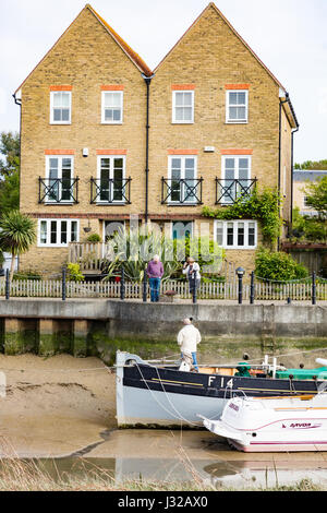 Un propriétaire du chaland parle aux propriétaires d'un développement moderne sur Faversham Creek, Faversham, Kent, UK Banque D'Images