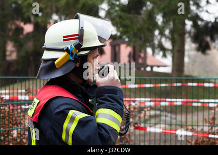 Chef pompier allemand utilisé un talkie walkie en action Banque D'Images
