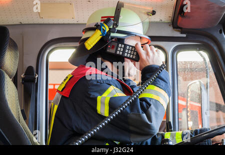 Pompier allemand dans un camion à incendie en action et utilisé un talkie walkie Banque D'Images
