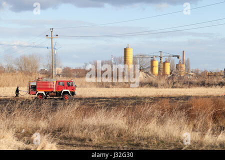 La lutte contre les incendies sur le terrain. Avec un camion de pompier et un tuyau d'incendie éteint le feu Banque D'Images