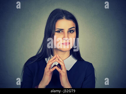 Closeup portrait of sneaky, Sly, intrigant jeune femme traçant quelque chose d'isolé sur fond gris. Des émotions négatives, les expressions du visage, frais Banque D'Images