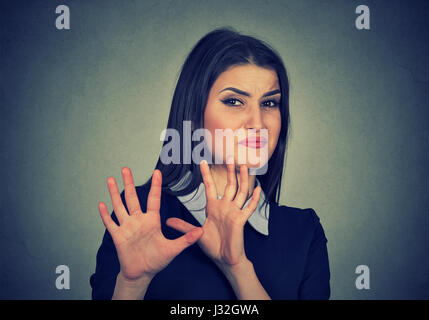 Jeune femme avec expression dégoûtée en esquivant quelque chose Banque D'Images