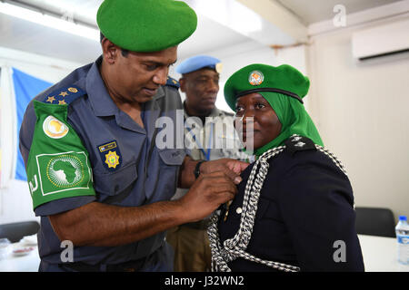 Cette image montre le commissaire de police de l’AMISOM, Anand Pillay, décernant une médaille à un officier de police individuel ougandais (IPO) qui a terminé sa mission en Somalie, soulignant le rôle des femmes dans le maintien de la paix. Banque D'Images