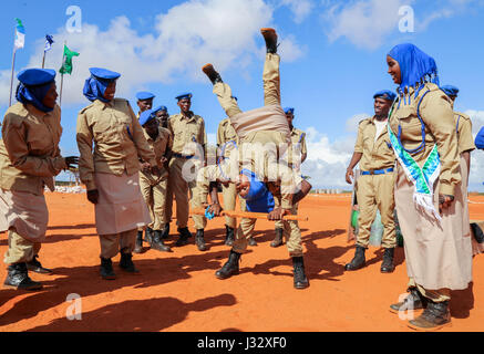 Les nouvelles recrues de la police somalienne (SPF) démontrer les compétences acquises pendant leur formation au cours d'un défilé de pour marquer la fin de leur formation à Kismaayo le 24 avril 2017. Photo de l'AMISOM Banque D'Images