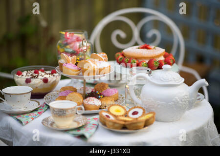 Une table préparée pour le thé l'après-midi / garden party dans un jardin. Banque D'Images