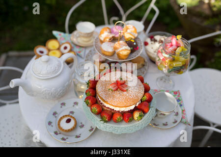 Une table préparée pour le thé l'après-midi / garden party dans un jardin. Banque D'Images