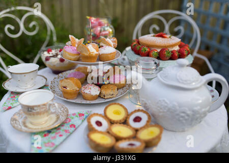 Une table préparée pour le thé l'après-midi / garden party dans un jardin. Banque D'Images