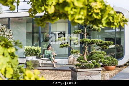 Femme assise sur une terrasse avec un iPad, coodo style de vie moderne, l'architecture moderne en Allemagne du nord, Hambourg, Allemagne Banque D'Images