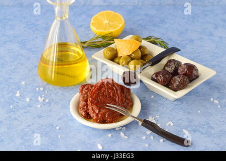 Un ensemble de plats de la cuisine grecque : olives, tomates séchées au soleil, citron, huile d'olive avec bol en verre. La cuisine grecque traditionnelle. Style de vie méditerranéen Banque D'Images