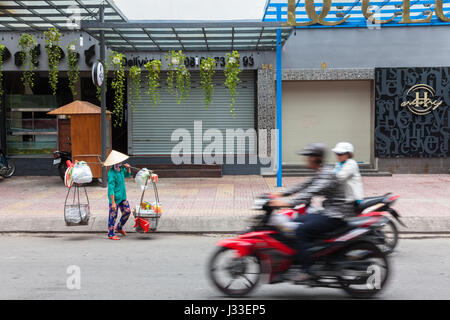 HO CHI MINH ville, VIETNAM - 24 novembre : Street food vendor en Chapeau conique traditionnel le 24 novembre 2015 à Ho Chi Minh City, Vietnam. Banque D'Images