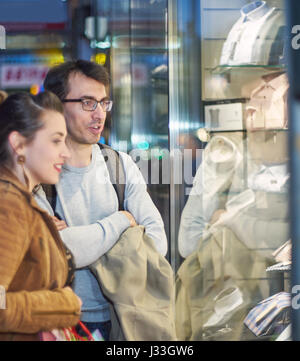 La femme et l'homme en face d'une boutique de vêtements Banque D'Images