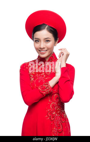 Charmante épouse vietnamienne en ao Dai rouge robe traditionnelle avec chapeau. Banque D'Images