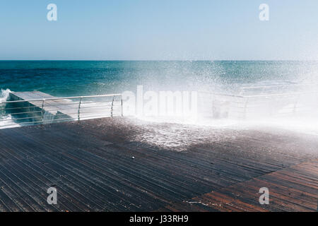 Les vagues déferlent sur la promenade. Météo ensoleillée et venteuse. Banque D'Images