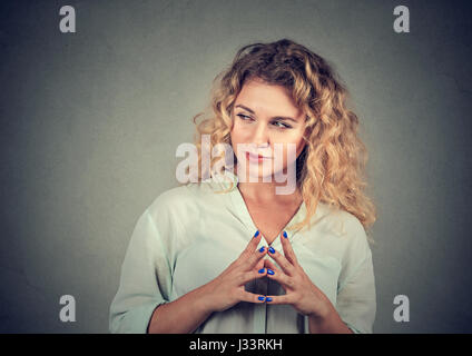 Closeup portrait of sneaky, Sly, intrigant jeune femme traçant quelque chose d'isolé sur fond gris. Des émotions négatives, les expressions du visage, frais Banque D'Images