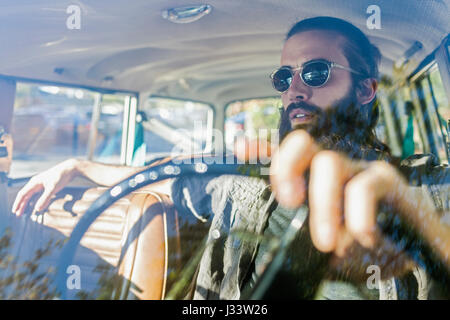 Beau jeune homme assis dans une voiture Banque D'Images