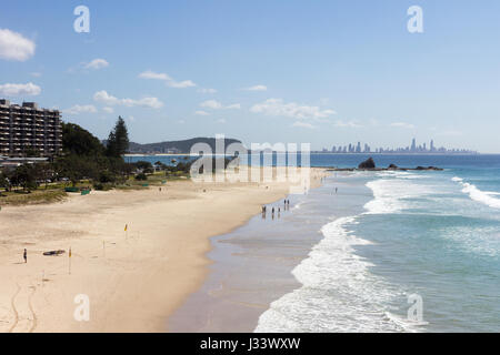 Les gens à l'extrémité nord de la plage de Currumbin avec Surfer's Paradise en arrière-plan, Gold Coast, Queensland, Australie Banque D'Images