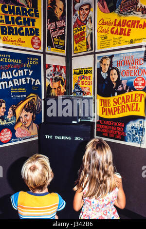 Deux enfants des années 80 à l'écoute de l'histoire de développement du cinéma dans les années 1930, Sydney, Australie. Banque D'Images