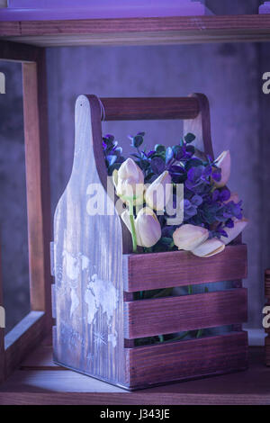 Fleurs sauvages dans une boîte de décoration. Fleurs bleu et blanc. Boîte en bois. Style de l'agriculture. Banque D'Images