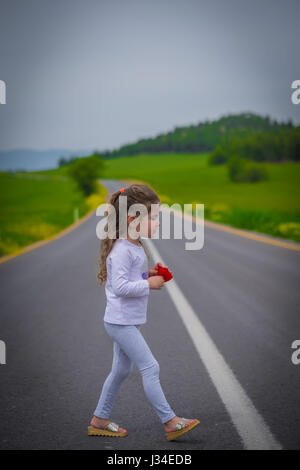 Kid girl au milieu de la route Banque D'Images