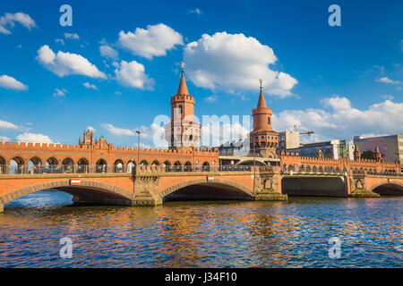 Belle vue sur célèbre Oberbaum Bridge traversant la rivière Spree sur une journée ensoleillée avec ciel bleu et nuages en été, Berlin, Allemagne Banque D'Images