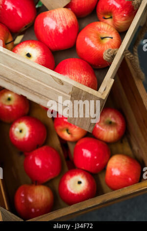 Gros plan Vue de dessus de caisse en bois boîte pleine de pommes rouges frais Banque D'Images