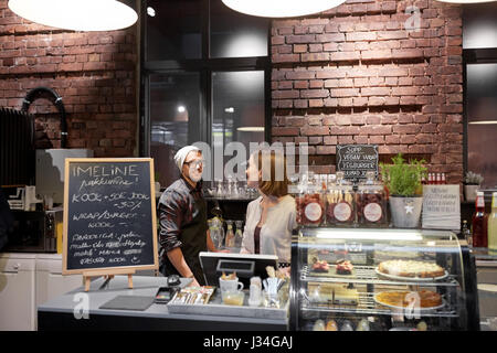 Heureux les barmans au café ou un café-restaurant counter Banque D'Images