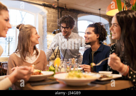 Heureux les amis boire et manger au restaurant Banque D'Images