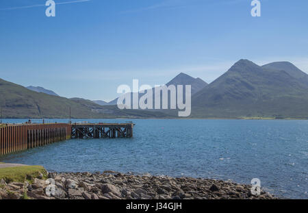 Vue de la montagnes Cuillin sur Skye prises à travers le son de Raasay depuis l'île de Raasay en Écosse avec le Suisnish Pier en premier plan Banque D'Images