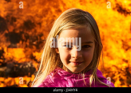 Portrait d'enfant petit fille blonde avec le feu et les flammes background Banque D'Images