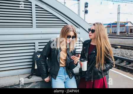 Deux femmes parlant dans la ville.de vie de plein air portrait de deux meilleurs amis hipster girls wearing veste en cuir élégant et des lunettes avec cofee, devenir fou et avoir beaucoup de temps ensemble Banque D'Images