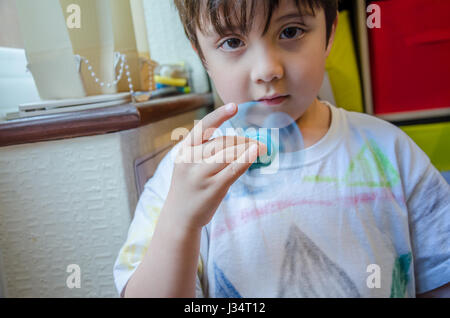 Un jeune garçon évoluant avec un spinner fidget. Banque D'Images